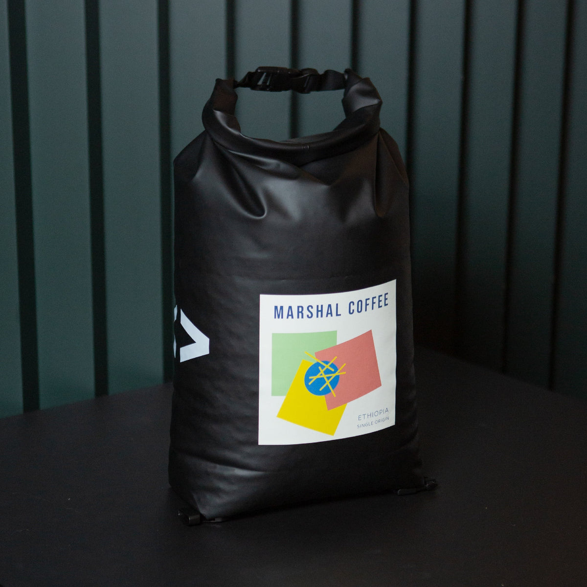 A black reusable food packaging bag for large wholesale B2B deliveries with a label featuring coffee roastery branding