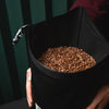 A black reusable food packaging bag for large wholesale B2B deliveries full of coffee and with a label featuring coffee roastery branding